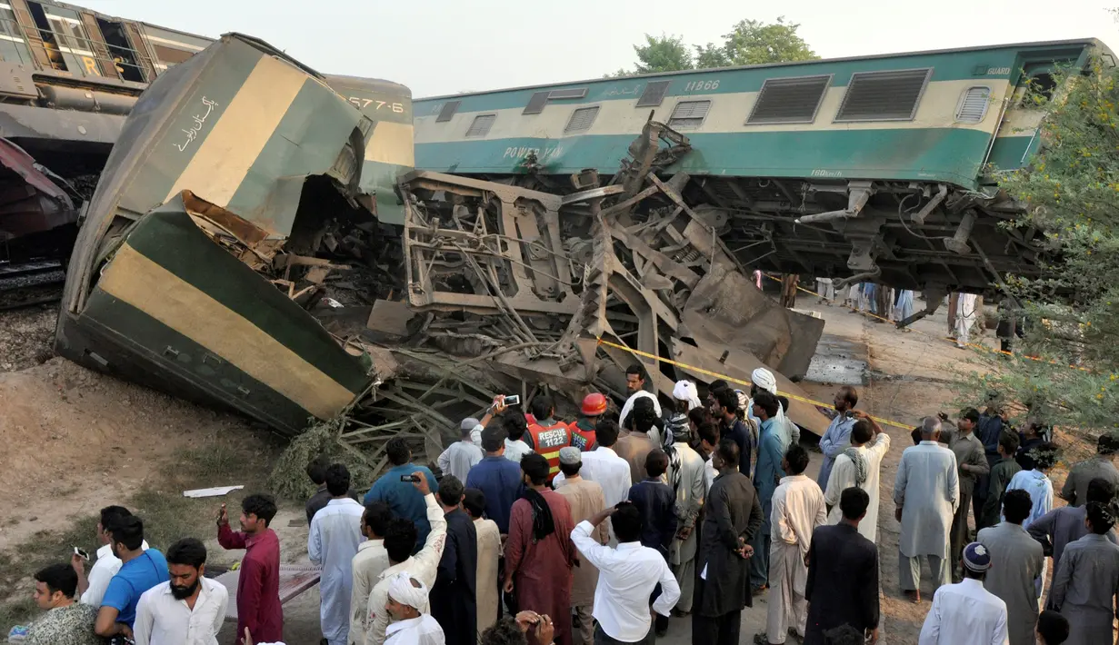 Warga setempat mengamati kondisi gerbong di lokasi tabrakan dua kereta api di Multan, Pakistan, Kamis (15/9). Akibat tabrakan, empat kereta dari rangkaian Awam Express terpental keluar jalur serta menghancurkan lokomotif. (REUTERS/Khalid Chaudry)