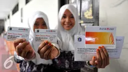 Dua orang siswa memperlihatkan Kartu Jakarta Pintar (KJP), Jakarta, Jumat (10/7/2015). Dengan adanya KJP tersebut diharapkan siswa-siswi yang tidak mampu dapat menikmati pendidikan dengan mudah dan terdata. (Liputan6.com/Yoppy Renato)
