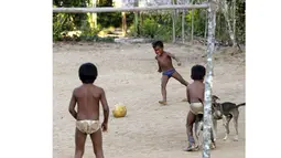 Beberapa anak dari suku Amazon Tatuyo terlihat asyik bermain bola di desanya, Rio Negro (Black River) tidak jauh dari kota tempat pertandingan Piala Dunia 2014, Manaus City, Brasil (23/6/2014). (REUTERS/Andres Stapff)