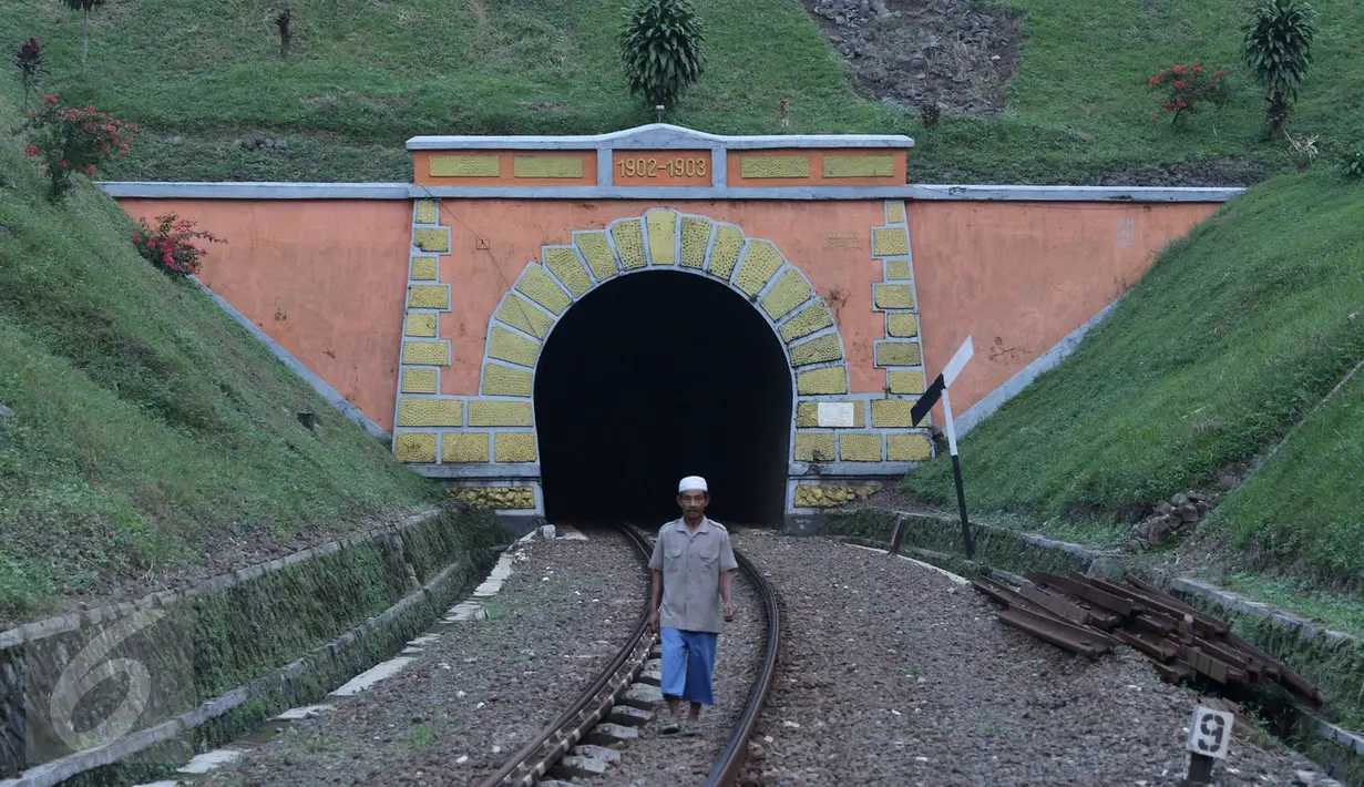 Warga melintas di rel sekitar terowongan Sasaksaat, Bandung Barat, Jawa Barat, Selasa (5/7). Terowongan yang memiliki panjang sekitar 949 meter tersebut menjadi terowongan kereta terpanjang di Indonesia yang masih aktif. (Liputan6.com/Immanuel Antonius)