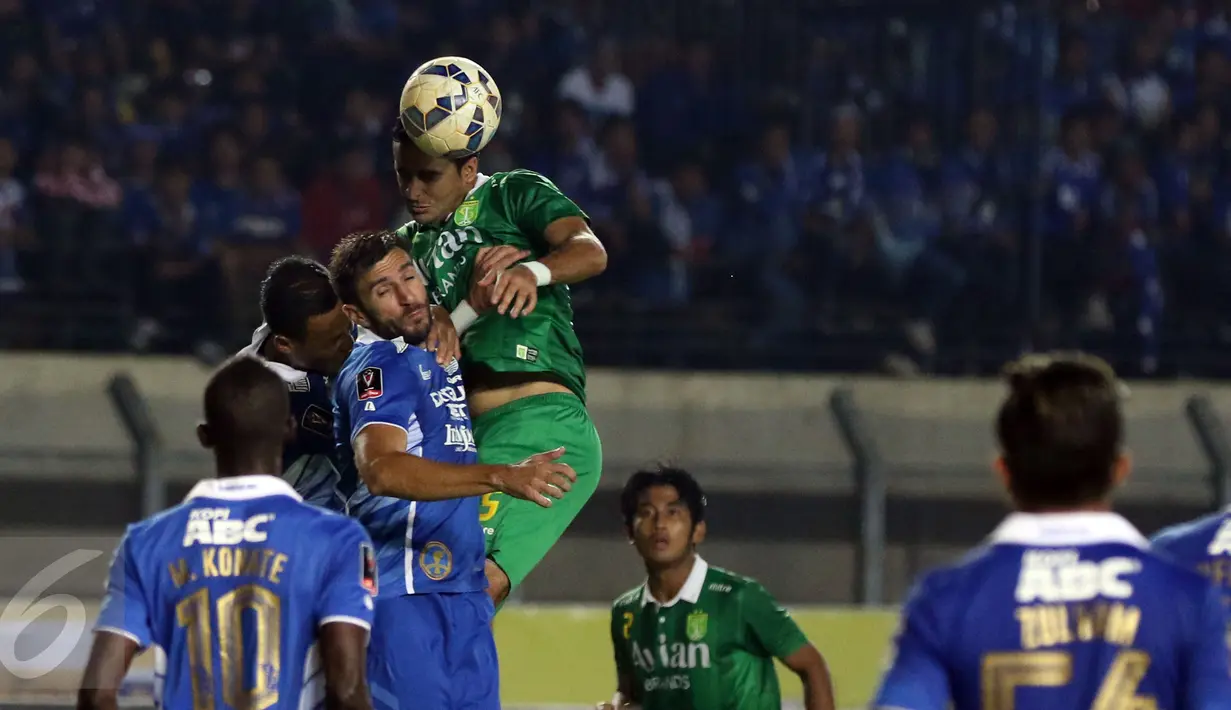 Bek Persebaya United, Otavio Dutra berebut bola atas dengan dua pemain Persib saat laga lanjutan Grup A Piala Presiden 2015 di Stadion Si Jalak Harupat, Bandung, Minggu (6/9/2015). Persebaya kalah 0-2 dari Persib. (Liputan6.com/Helmi Fithriansyah)