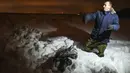 Seorang pria menunjukkan bagian dari puing-puing pesawat Rusia, Saratov Airlines di distrik Ramensky, pinggiran Moskow, Minggu (11/2). Pesawat yang membawa 71 orang itu jatuh tak lama setelah lepas landas dari bandara Domodedovo. (Vasily MAXIMOV /AFP)