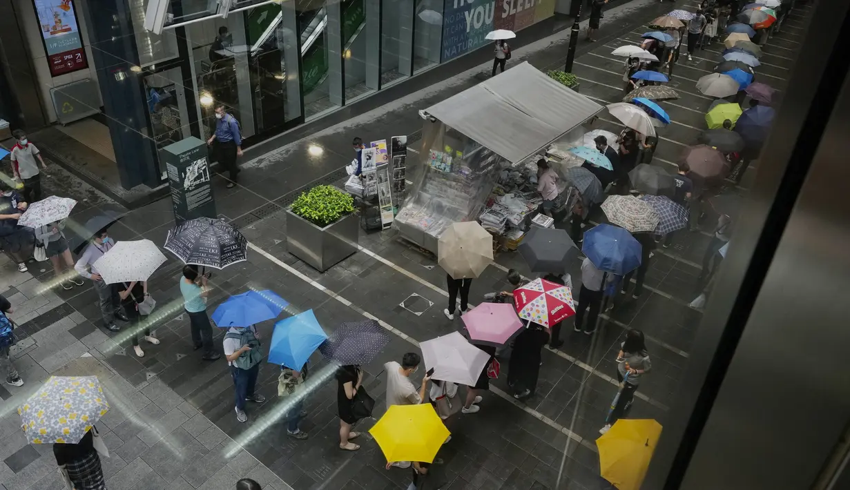 Orang-orang mengantre untuk edisi terakhir Apple Daily di stan surat kabar di sebuah jalan pusat kota di Hong Kong, Kamis (24/6/2021). Apple Daily didirikan oleh raja media Jimmy Lai pada 1995 dan pada awalnya dikenal sebagai tabloid gosip mengenai selebritas. (AP Photo/Vincent Yu)