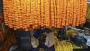 Seorang pria membuat karangan bunga jelang Festival Diwali di pasar bunga New Delhi, India, Minggu (31/10/2021). Festival Diwali atau Festival Cahaya dalam agama Hindu melambangkan kemenangan baik atas buruk. (Money SHARMA/AFP)