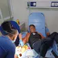 Roni, salah satu korban kekejaman Dadang Buaya, mengalami luka robek di bagian punggung sebelah kanan dan tangan kanan, tengah mendapatkan perawatan petugas kesehatan. (Liputan6.com/Jayadi Supriadin)