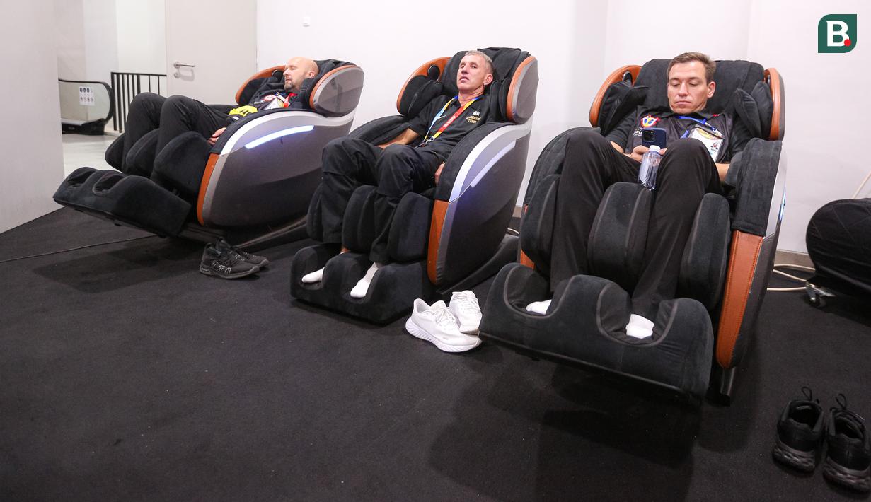 Tiga jurnalis asing meraskan kursi pijat otomatis saat Piala Dunia FIBA 2023 di Indonesia Arena, Senayan, Jakarta, Jumat (01/09/2023). (Bola.com/Bagaskara Lazuardi)