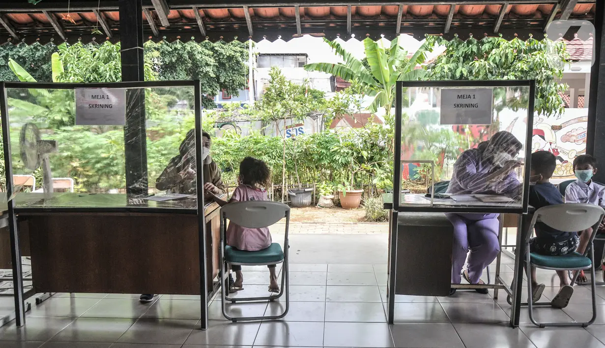 Petugas puskesmas memeriksa kesehatan anak sebelum mengikuti vaksin DT di RPTRA Citra Permata, Jakarta, Selasa (28/9/2021). Kegiatan rutin tahunan tersebut bertujuan memberikan kekebalan tubuh pada anak sekolah terhadap penyakit DT dengan kuota 150 anak per hari. (merdeka.com/Iqbal S Nugroho)