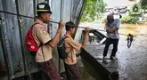 Dua orang pelajar bersiap naik perahu eretan untuk menyeberangi kali Ciliwung di kawasan Manggarai, Jakarta, Rabu (14/5/2025). (Liputan6.com/Angga Yuniar)