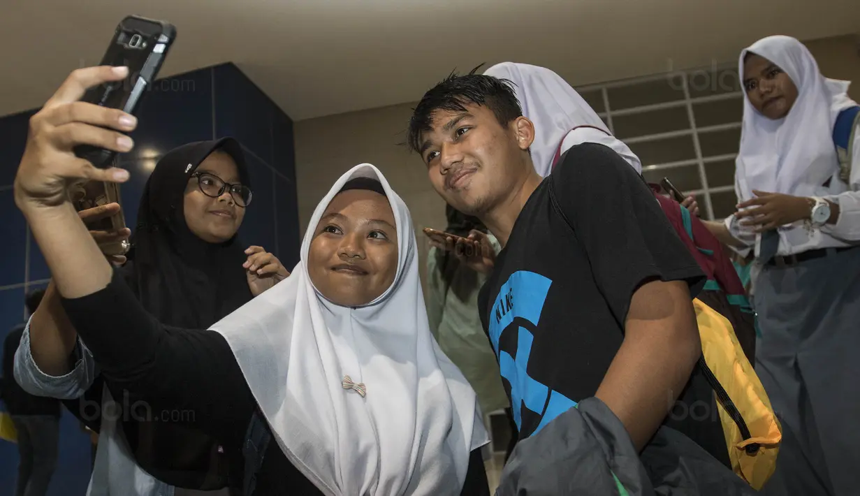 Gelandang Timnas Indonesia U-19, Witan Sulaeman, selfie bersama fans usai latihan di Stadion Wibawa Mukti, Bekasi, Senin (16/10//2017). Kehadiran fans dengan senang hati disambut pemain Timnas U-19. (Bola.com/Vitalis Yogi Trisna)