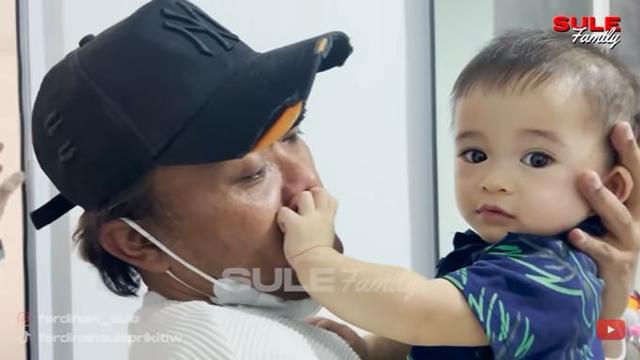 Lama tak berjumpa, akhirnya Sule mendatangi rumah Nathalie Holscher. Saat digendong, Adzam tak mau lepas dari pelukan ayahnya. (Foto: YouTube/Sule Family)