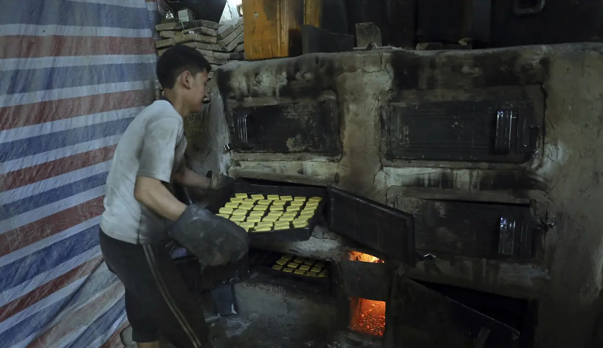 Seorang tukang roti memasukkan penganan manis ke dalam oven di toko roti tradisional menjelang bulan puasa Ramadan mendatang, di Kabul, Afghanistan, pada 7 April 2021. Sebentar lagi, umat Muslim di seluruh dunia akan menyambut bulan Ramadan.  (AP Photo / Rahmat Gul)