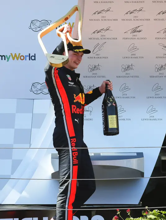 Pebalap Red Bull, Max Verstappen membawa trofi dan sampanye usai memenangkan F1 GP Austria di Red Bull Ring, Spielberg, Minggu (30/6/2019). Max Verstappen menggeser Sebastian Vettel dari peringkat ketiga klasemen F1. (ERWIN SCHERIAU/APA/AFP)