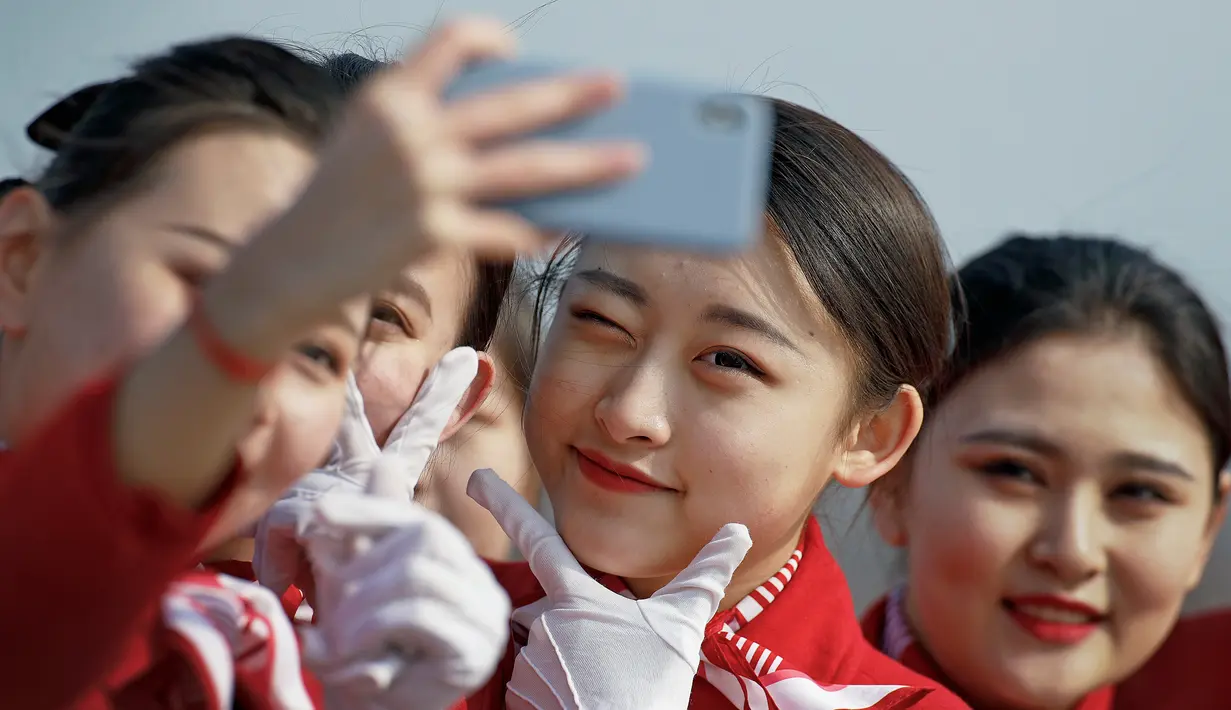 Sejumlah wanita berswafoto di sela penyambutan para peserta Kongres Rakyat Nasional di Beijing, China, Senin (4/3). Para wanita berparas cantik tersebut bertugas menyambut para tamu yang menghadiri kongres. (AP Photo/Andy Wong)