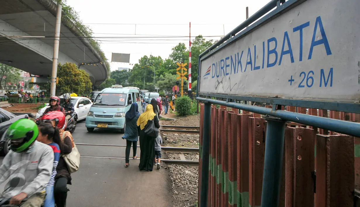 Warga dan pengendara melintas di pintu pelintasan Kereta di Kalibata, Jakarta, (4/12). Pemerintah DKI Jakarta berencana bangun jalan layang atau terowongan di pelintasan-pelintasan sebidang untuk mencegah kecelakaan. (Liputan6.com/Yoppy Renato)