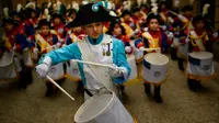 Seorang anak mengenakan seragam memimpin grupnya untuk memukul drum saat perayaan La Tamborrada di kota Basque San Sebastian, Spanyol (20/1). Acara ini bertujuan untuk menghormati santo pelindung mereka. (AP Photo / Alvaro Barrientos)