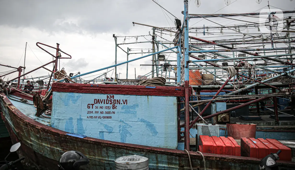 Nelayan beraktivitas di perahu saat bersandar di Pelabuhan Muara Angke, Jakarta, Senin (26/12/2022). Akibat angin  barat dan gelombang tinggi menyebabkan nelayan tradisional di Muara Angke libur melaut. (Liputan6.com/Faizal Fanani)