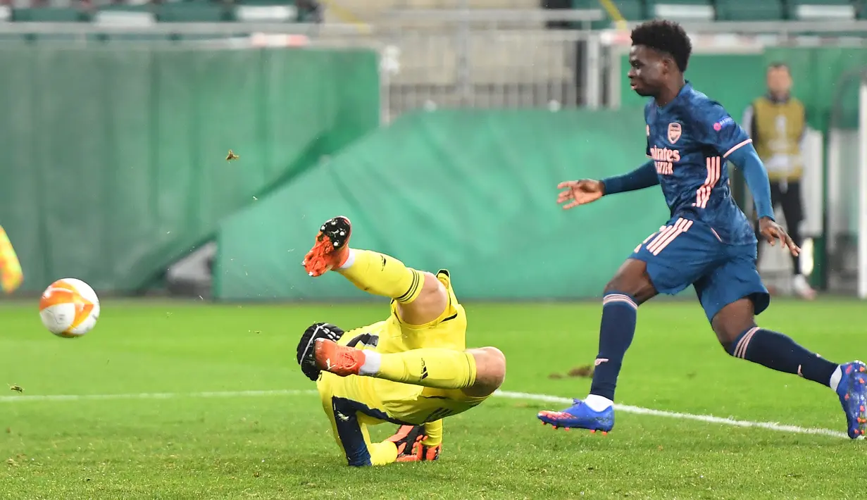 Penyerang Arsenal, Bukayo Saka, berusaha mencetak gol ke gawang Rapid Vienna pada laga Grup B Liga Europa 2020/2021 di Allianz Stadion, Kamis (22/10/2020) malam WIB. Arsenal menang 2-1 atas Rapid Vienna. (AFP/Joe Klamar)