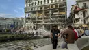 <p>Orang-orang menyaksikan upaya penyelamatan pada lokasi ledakan mematikan yang menghancurkan Hotel Saratoga di Havana, Kuba, 6 Mei 2022. Ledakan kuat yang diduga disebabkan oleh kebocoran gas alam menewaskan 18 orang dan melukai puluhan orang. (AP Photo/Ramon Espinosa)</p>