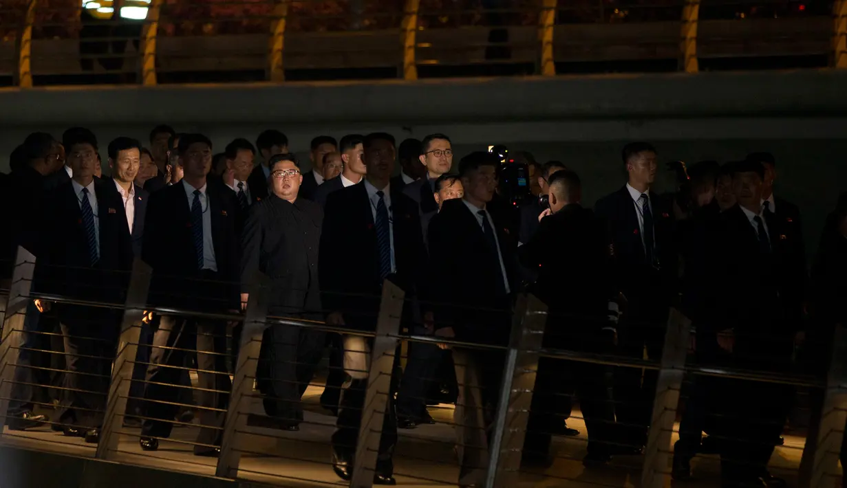 Pemimpin Korea Utara Kim Jong-un mengunjungi Marina Bay sebelum pertemuan bersejarahnya dengan Presiden AS, Donald Trump di Singapura, Senin (11/6). Kedatangan Kim Jong-un dikawal ketat para bodyguard. (AP Photo/Gemunu Amarasinghe)
