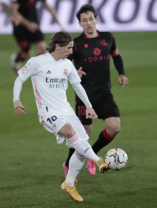 Gelandang Real Madrid, Luka Modric berusaha mengumpan bola dari kawalan pemain Real Sociedad, Mikel Oyarzabal pada pertandingan La Liga Spanyol di stadion Alfredo di Stefano di Madrid, Spanyol, Selasa (2/3/2021). Madrid kini ada di posisi ketiga dengan 53 poin. (AP Photo/Bernat Armangue)