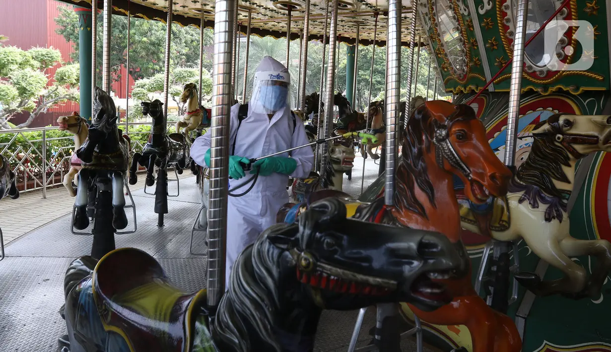 Petugas menyemprotkan cairan disinfektan di wahana permainan di Dufan, Ancol, Jakarta, Sabtu (12/9/2020). Pemprov DKI berencana menutup sejumlah tempat rekreasi di antaranya Ancol, Ragunan, Monas, dan Taman Mini Indonesia Indah saat PSBB total, 14 September mendatang. (Liputan6.com/Herman Zaharia)