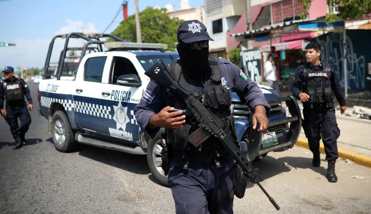 Polisi menjaga klub penari telanjang yang menjadi lokasi penyerangan di Coatzacoalcos, Veracruz, Meksiko, Rabu (28/8/2019). Setelah melakukan penembakan, para pelaku penyerangan menghalangi pintu keluar dan mulai membakar seluruh bangunan klub. (AP Photo/Felix Marquez)