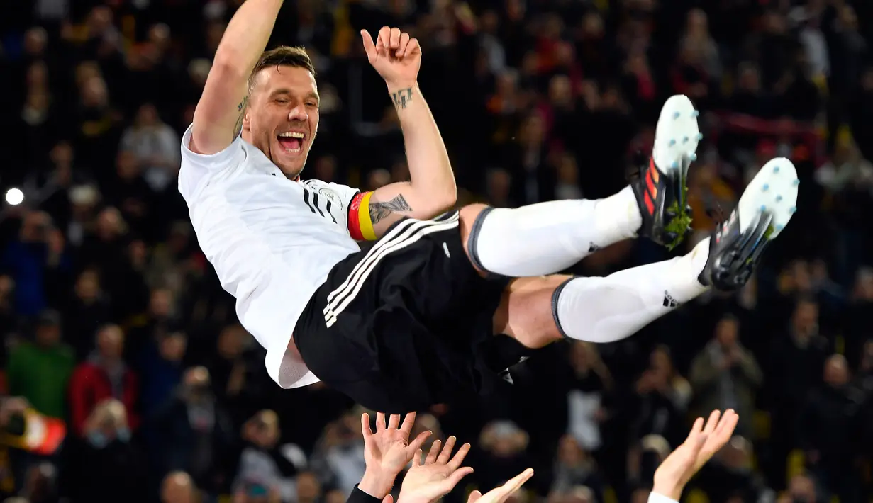 Penyerang Jerman, Lukas Podolski melakukan selebrasi bersama setelah pertandingan persahabatan antara Jerman dan Inggris di Dortmund, (23/3). Pertandingan ini merupakan laga terakhir Podolski bersama tim nasional Jerman. (AP/Martin Meissner)