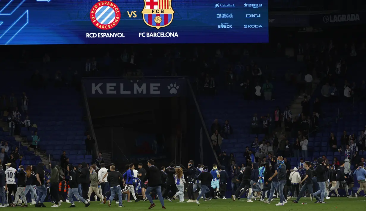 Selebrasi kemenangan yang dirayakan pemain Barca di lapangan ini membuat penggemar tuan rumah ricuh memasuki lapangan. (AP Photo/Joan Monfort)