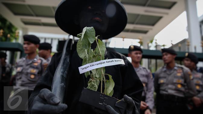 Peserta aksi mengecat tubuhnya dan membawa tumbuhan saat menggelar unjuk rasa di depan Mahkamah Agung, Jakarta, Kamis (2/6/2016). Dalam aksinya, massa menuntut pemerintahan Jokowi untuk menyelesaikan konflik Agraria. (Liputan6.com/Faizal Fanani)