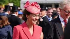 Kate Middleton, Duchess of Cambridge dari Inggris berbicara kepada para tamu di Pesta Taman Kerajaan di Istana Buckingham di London (18/5/2022). Kate Middleton tampak anggun dalam gaun mantel versi koral berwarna merah muda. (AFP/Pool/Dominic Lipinski)