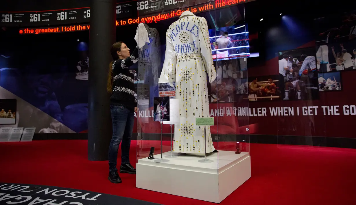 Petugas membersihkan etalase kaca berisi jubah milik Muhammad Ali, pada sesi pemotretan pameran tentang Ali bertajuk "I Am The Greatest", di O2 Arena, London, Kamis (3/3). Pameran tersebut tentang perjalanan hidup Ali di olahraga tinju (JUSTIN TALLIS/AFP)