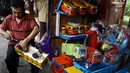 Pedagang memperbaiki mobil kayu yang akan di jual di kios mainan kayu, Jakarta (27/5/2015). Produksi mainan lokal dan tradisional diharapkan mampu bertahan, mengingat pasar bebas Asean yang dimulai Januari 2016 mendatang. (Liputan6.com/Johan Tallo)