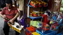 Pedagang memperbaiki mobil kayu yang akan di jual di kios mainan kayu, Jakarta (27/5/2015). Produksi mainan lokal dan tradisional diharapkan mampu bertahan, mengingat pasar bebas Asean yang dimulai Januari 2016 mendatang. (Liputan6.com/Johan Tallo)
