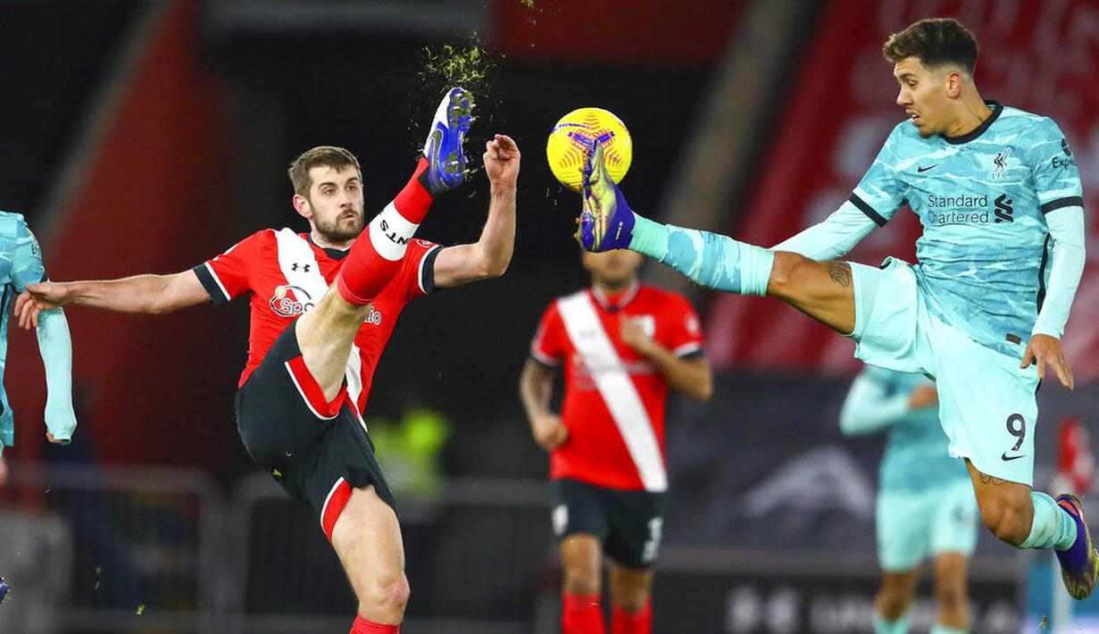 Pemain Southampton, Jack Stephens, berebut bola dengan penyerang Liverpool, Roberto Firmino, pada laga Liga Inggris di Stadion St Mary's, Selasa (05/01/2021). Liverpool takluk 1-0 dari Southampton. (AP Photo/Michael Steele,Pool)