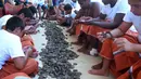 Sejumlah penyelam mengupas cangkang kerang yang sudah ditangkap selama musim berburu mutiara tahunan di lepas pantai kota pelabuhan Khairan, Kuwait (2/8). Warga Kuwait Berburu mutiara setiap tahun sekali. (AFP PHOTO/Yasser Al-Zayyat)