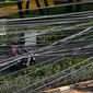 Kendaraan melintas di bawah kabel listrik dan kabel optik yang terlihat semrawut di kawasan Taman Puring, Jakarta, Jumat (3/7/2020). Tidak ada aturan yang baku membuat satu tiang listrik bisa digunakan berbagai kabel baik itu listrik ataupun optik dari berbagai provider. (Liputan6.com/Johan Tallo)
