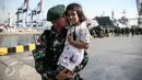 Seorang personel TNI-AD berpose dengan anaknya di Pelabuhan Kolinlamil, Jakarta, Senin (9/5). Sebanyak 450 personel TNI-AD dari Satgas Yonif Para Raider 330 inf 1 Kostrad dilepas untuk misi pengamanan perbatasan RI-PNG. (Liputan6.com/Faizal Fanani)