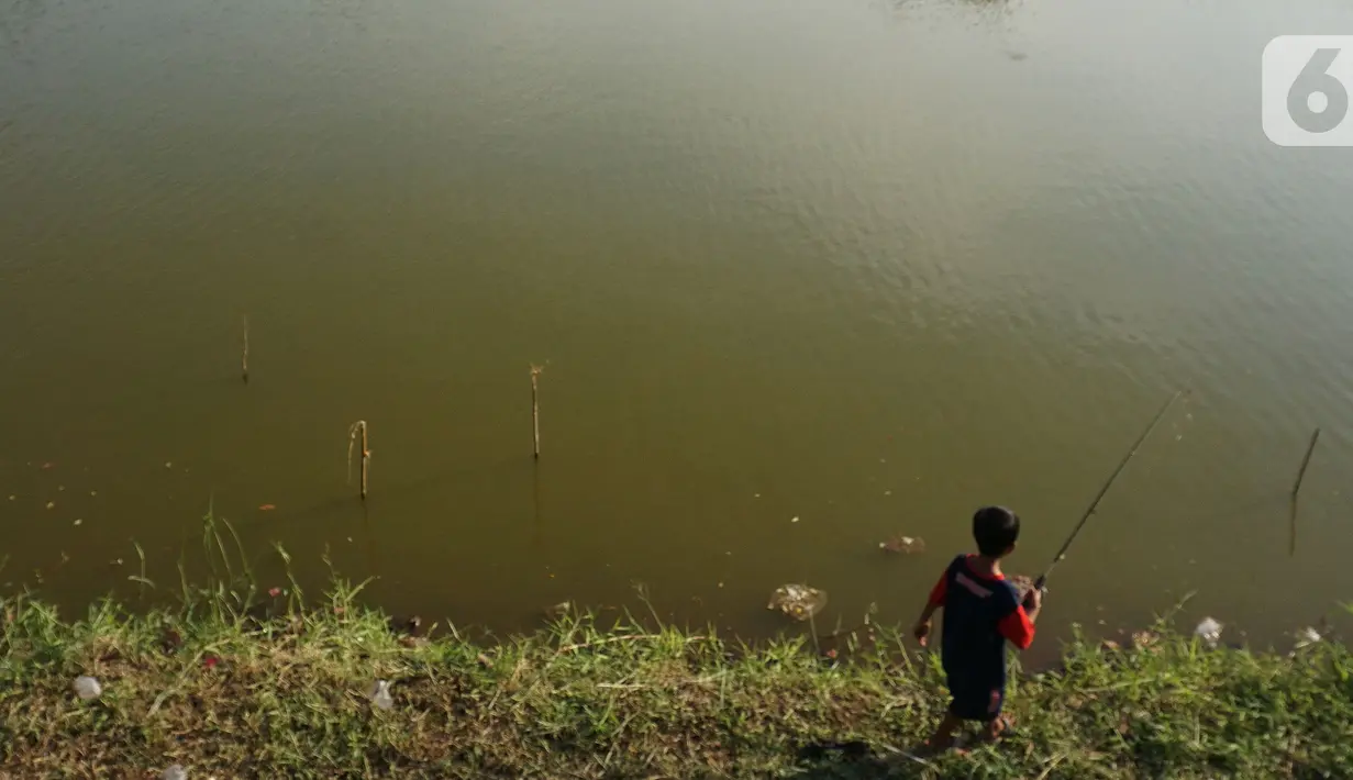Seorang anak memancing di Waduk Cavalio, Jakarta, Jumat (4/10/2019). Dinas Sumber Daya Air DKI Jakarta mengalokasikan anggaran sebesar Rp 288,49 miliar pada 2020 untuk program naturalisasi sungai dan waduk guna mengatasi masalah banjir di Ibu Kota. (Liputan6.com/JohanTallo)