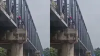 Upaya penyelamatan ibu dan anaknya yang akan bunuh diri di jembatan di Bojonegoro. (Adirin/Liputan6.com)
