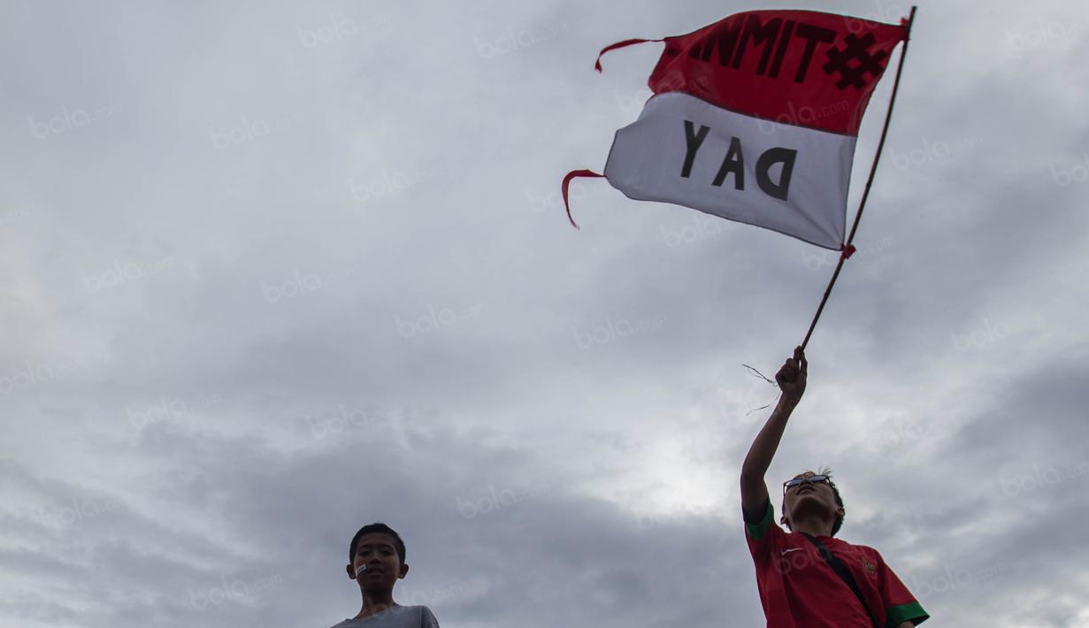 Seorang suporter mengibarkan bendera merah putih saat mendukung Timnas Indonesia yang akan bertanding melawan Vietnam di Stadion Pakansari, Jawa Barat, Sabtu (3/12/2016). (Bola.com/Vitalis Yogi Trisna)