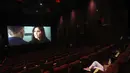 Orang-orang menonton film Bollywood India saat bioskop dibuka kembali dengan pemutaran khusus untuk prajurit COVID-19 dan keluarga mereka di bioskop PVR di New Delhi, India (15/101/2020). (AP Photo/Manish Swarup)