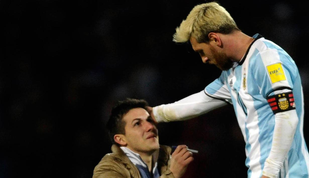 Fans itu disebut beberapa media masuk ke lapangan untuk memohon agar Lionel Messi tidak pensiun dari timnas Argentina. (AFP/Andres Larrovere)