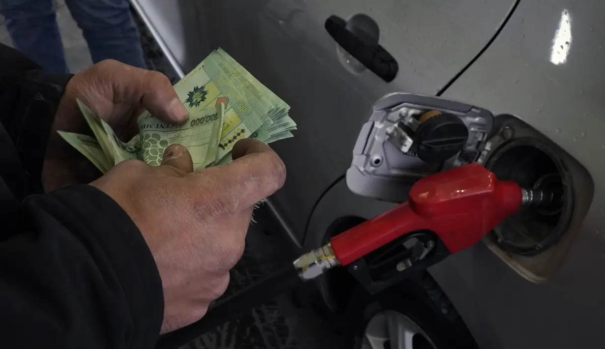 Seorang pekerja menghitung uang di sebuah pompa bensin di pinggiran selatan Beirut, Dahiyeh, Lebanon, pada 15 Maret 2022. Melonjaknya harga energi dan makanan yang dipicu oleh invasi Rusia ke Ukraina mendorong beberapa negara Timur Tengah ke tepi jurang. (AP Photo/Bilal Hussein)