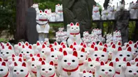 Patung-patung kucing yang disebut maneki-neko menghiasi kuil Gotokuji di Tokyo, Jepang, 6 Agustus 2018. Kuil Gotokuji di Tokyo telah lama menarik pengunjung dengan ribuan patung kucing putihnya, yang dianggap membawa keberuntungan. (AFP/Martin BUREAU)
