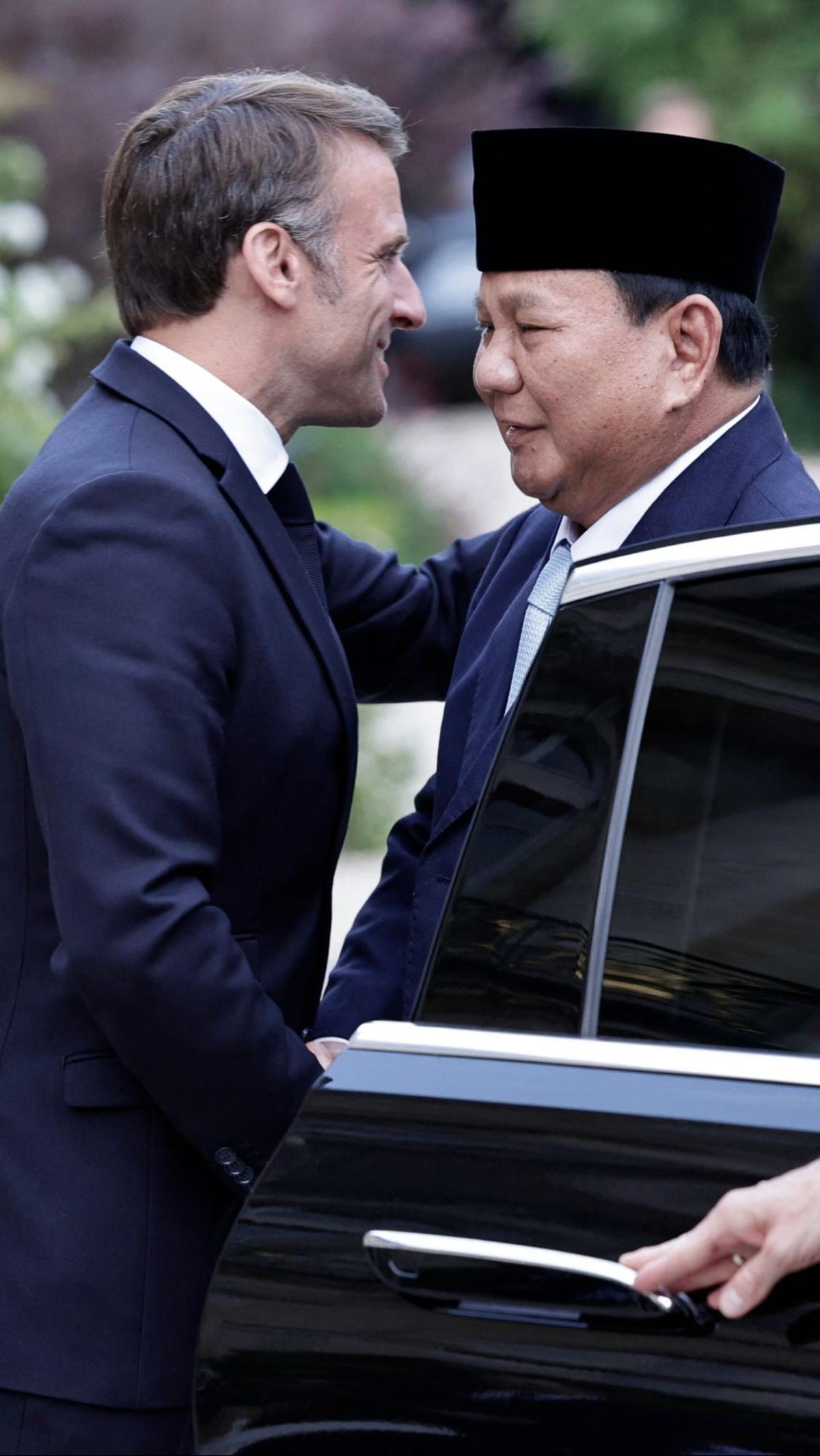 Prabowo tampak disambut senyum dan peluk hangat dari Macron saat turun dari mobil. Foto: Stephane De Sakutin/AFP