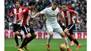 Pemain Real Madrid, Karim Bezema mencoba melewati kawalan para pemain Athletic Bilbao pada lanjtan La Liga Spanyol pekan ke-24 di Stadion Santiago Bernabeu,  Madrid, Sabtu (13/2/2016).  (AFP / Gerrard Julien)