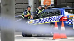 Petugas kepolisian memblokade lokasi dimana sebuah mobil menghantam para pejalan kaki di pusat kota Melbourne, Australia, Jumat (20/1). Seorang pria diduga sengaja menabrakkan mobilnya ke arah pejalan kaki di Jalan Bourke. (AP Photo/Andrew Brownbill)