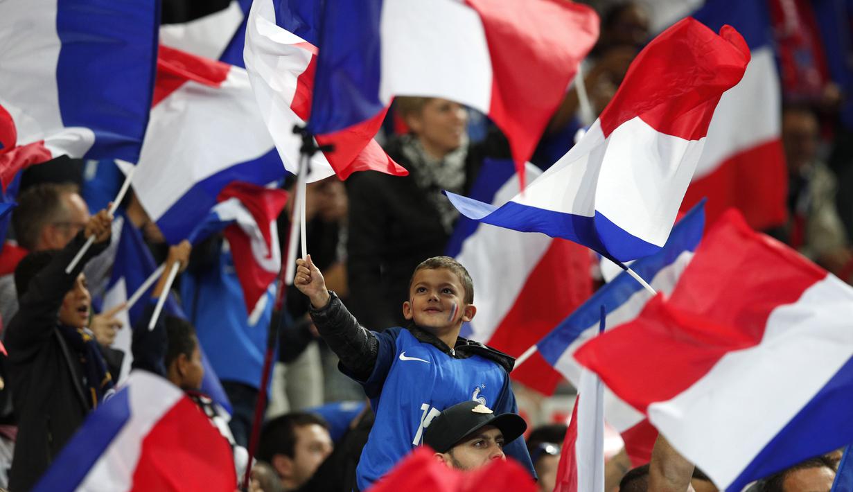 Suporter Cilik mengibarkan bendera Prancis saat mendukung timnya melawan Belarusia pada kualifikasi Piala Dunia 2018 grup A di Stade de France stadium, Saint-Denis (10/10/2017). Prancis menang 2-1. (AP/Christophe Ena)