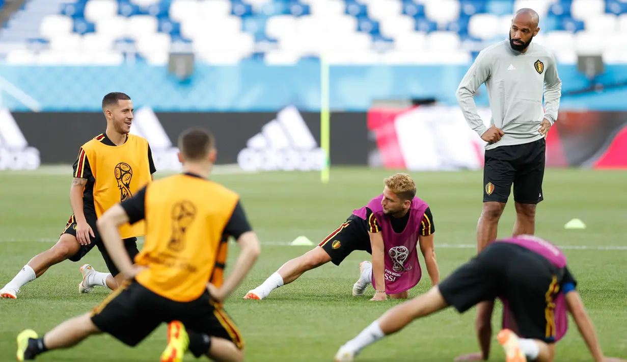 Asisten pelatih Belgia Thierry Henry melihat para pemainnya melakukan pemanasan saat latihan di stadion Kaliningrad,  Rusia (27/6). Belgia akan bertanding melawan Inggris pada grup G Piala Dunia 2018. (AP Photo/Alastair Grant)