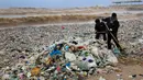 Pekerja membersihkan tumpukan sampah yang menutupi pantai Zouq Mosbeh di utara Beirut, 22 Januari 2018. Lautan sampah itu menumpuk setelah disapu gelombang besar yang ditimbulkan oleh hantaman badai di Lebanon akhir pekan lalu. (AP/Hussein Malla)